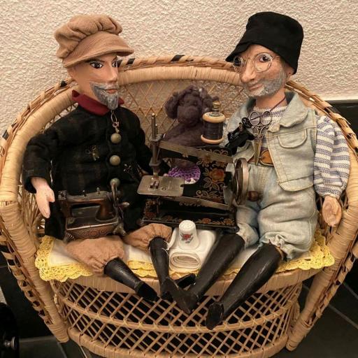 Zwei detailreiche Miniaturfiguren in einem geflochtenen Korb mit Miniatur-Accessoires.