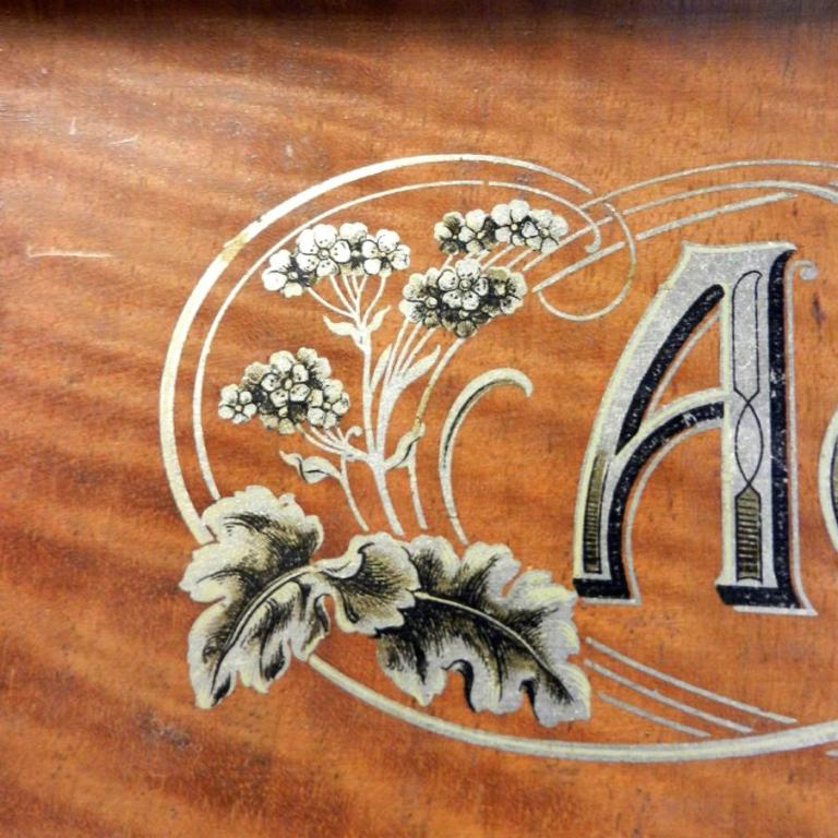 Dekoratives Initial 'A' mit floralen Verzierungen auf Holz