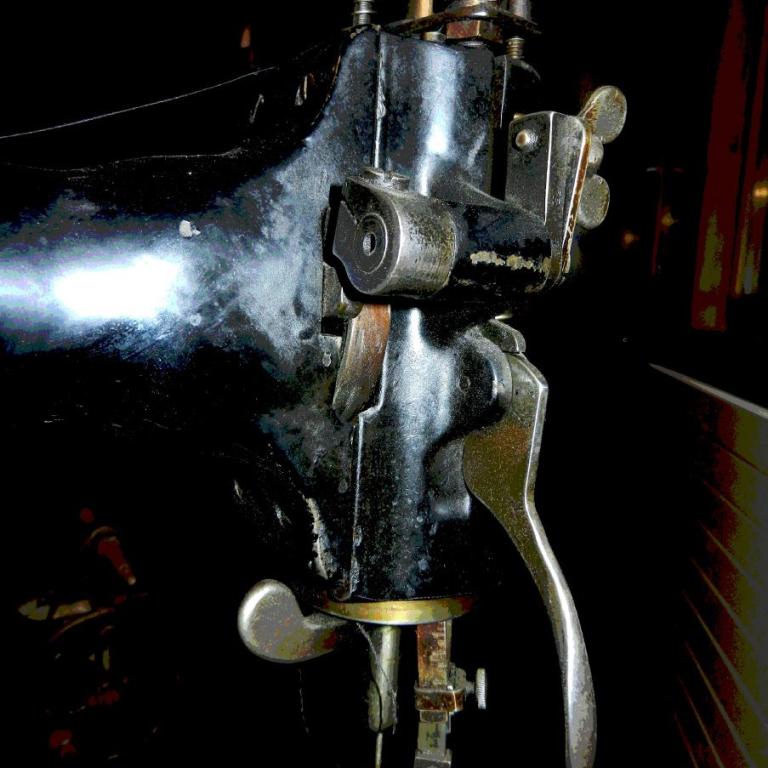 Nahaufnahme eines komplexen, verchromten mechanischen Nähmaschinenbauteils.